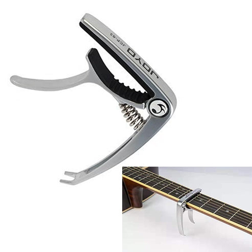 Silver zinc alloy guitar capo with black fret-pressing pad, on acoustic guitar