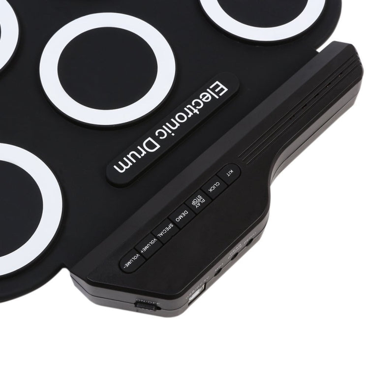 Portable electronic drum control panel on black silicone pad with buttons and ports