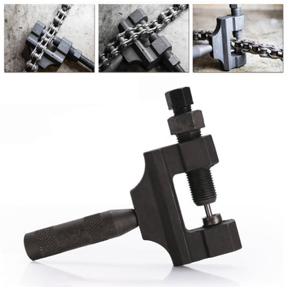 Chain removal tool with threaded press, clamped onto a metal bike or motorcycle chain
