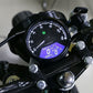 Mounted retro motorcycle LCD odometer on handlebars with blue-lit screen