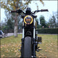 Retro motorcycle LED headlight with amber halo light on a black motorcycle front