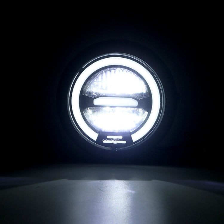 Round motorcycle LED headlight emitting bright white light, clear lens and black rim
