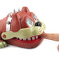 Dog bite toy close-up with cream jaw plate, silver spikes, and visible white fangs.
