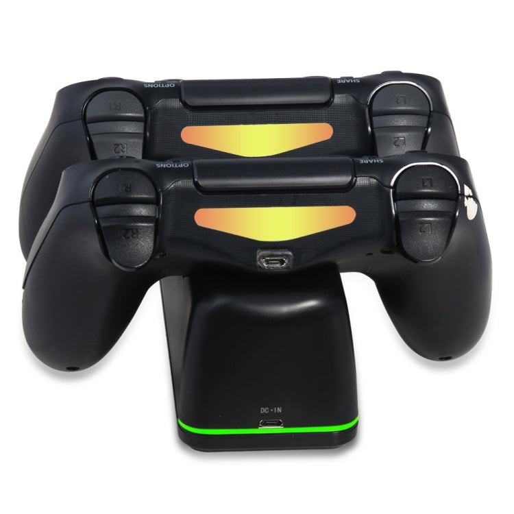 Black game controller resting on dual charging dock with green LED strip
