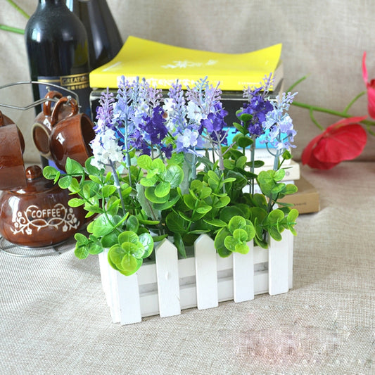White wooden fence planter with purple and green artificial flowers