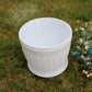 White plastic barrel-style flower pot with ribbed sides and round rim