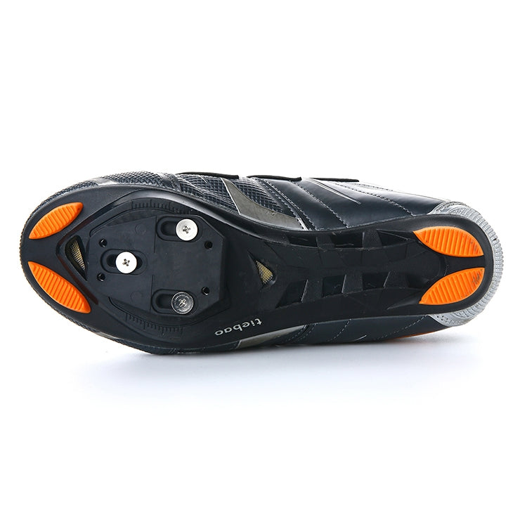 Black cycling shoe sole with cleat hardware and orange traction pads