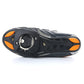 Underside of cycling shoe with black cleat cover and orange side accents