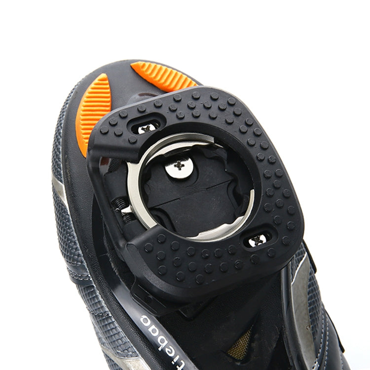 Close-up of black cleat cover with circular opening and orange backing tab