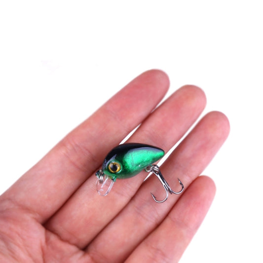 Green fishing lure with clear lip and treble hooks held in a hand