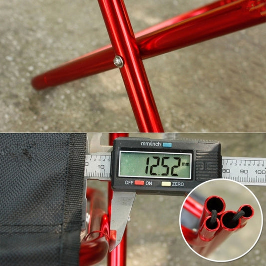 Portable folding stool with red metal legs and black seat fabric, close-up fit check.