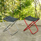 Two portable folding stools with black fabric seats, one silver frame and one red frame.