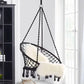 Black rope hanging swing chair with oval net seat and tassel fringe, with cushions