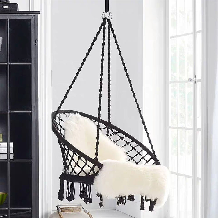 Black rope hanging swing chair with oval net seat and tassel fringe, with cushions