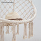 Beige hand-woven rope hanging swing chair with round net seat and fringed edges