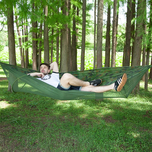 Green parachute hammock with attached mosquito net and wide fabric spread