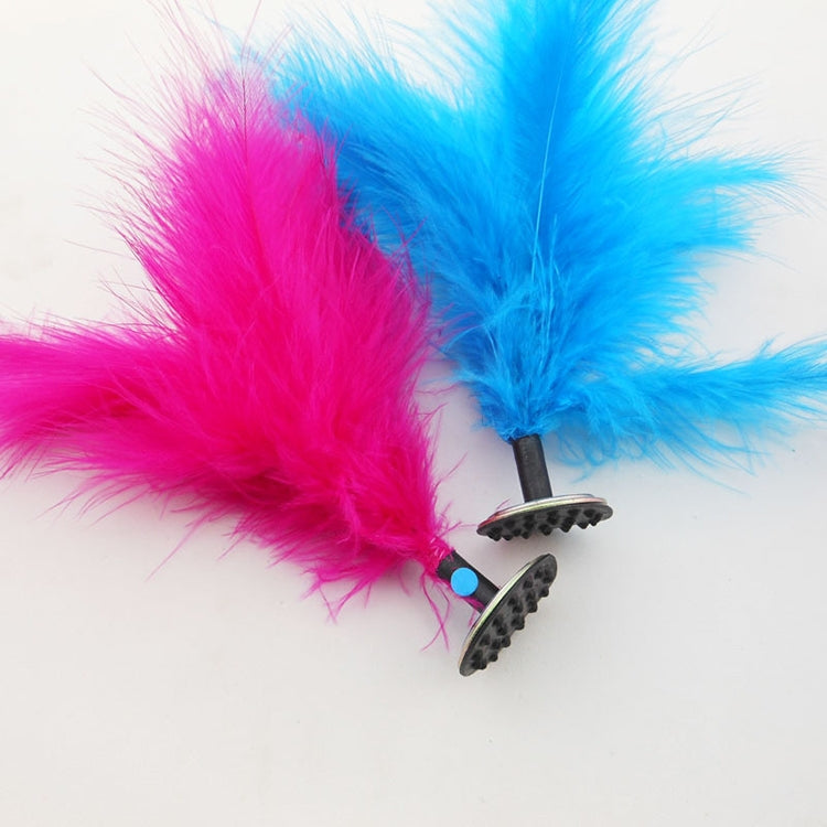 Close-up of blue and pink feather kick shuttlecock heads on round black-tread bases