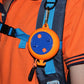 Orange and blue retractable clothesline reel clipped to a backpack strap