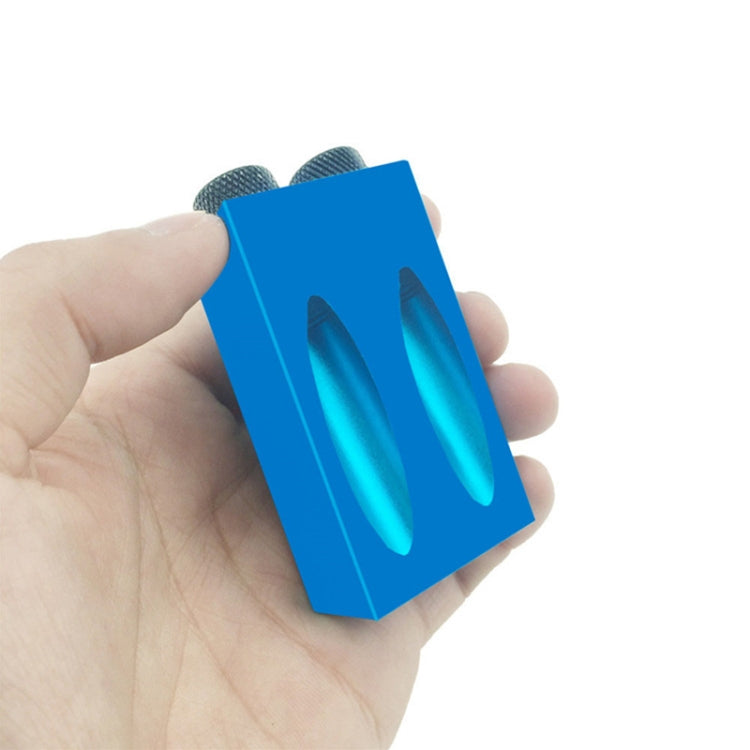 Blue angled hole locator held in hand, showing two slot guide openings
