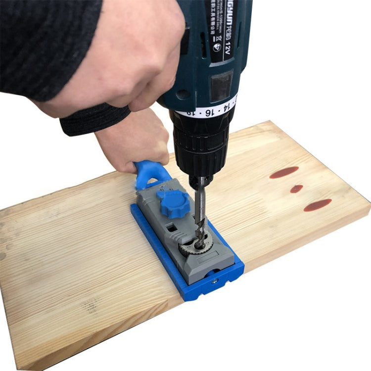 Woodworking borehole locator jig on wood with mounted drill bit