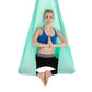 Light teal aerial yoga hammock with mesh canopy, person holding side straps