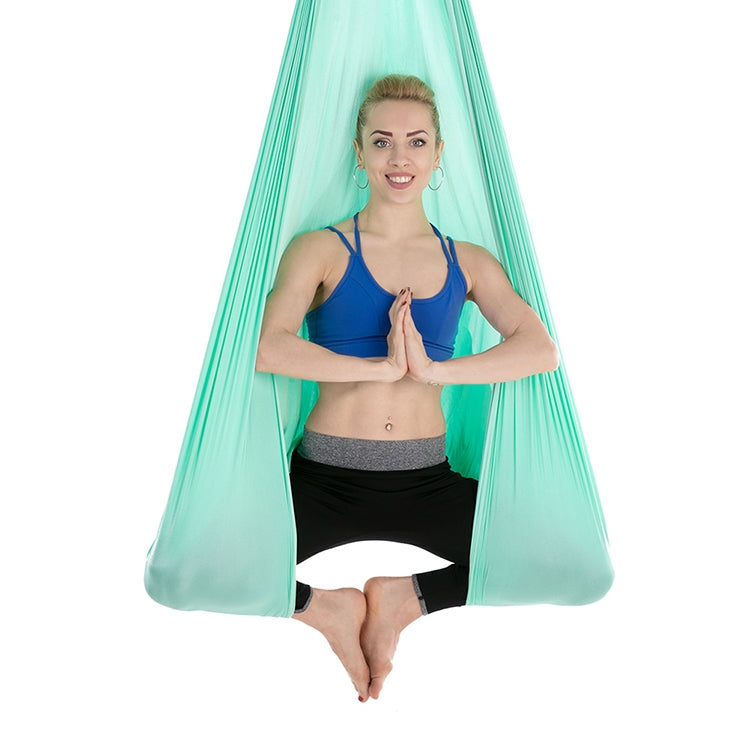 Light teal aerial yoga hammock with mesh canopy, person holding side straps