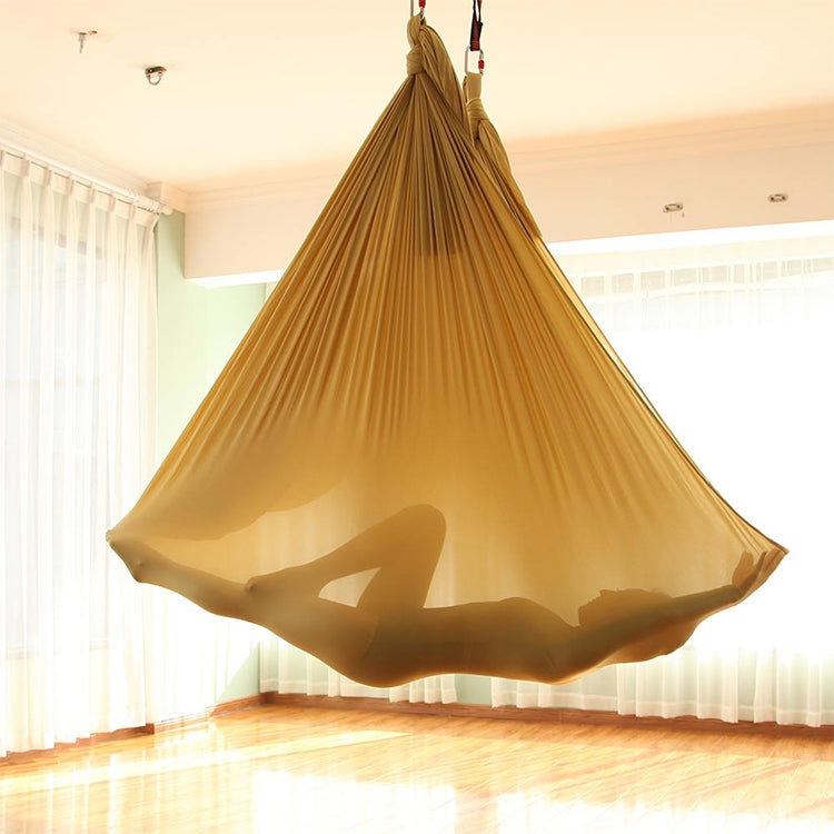Gold aerial yoga hammock canopy with hanging straps, set for aerial stretching