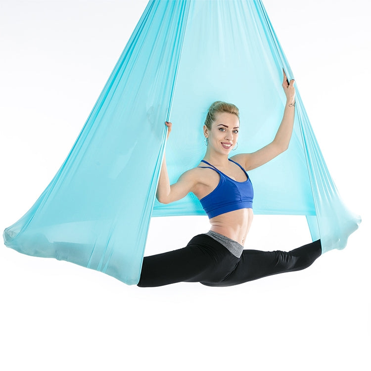 Sky blue aerial yoga hammock with mesh canopy, person performing a leg stretch