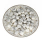 Simulated bird eggs, white speckled eggs arranged in patterned ceramic dish