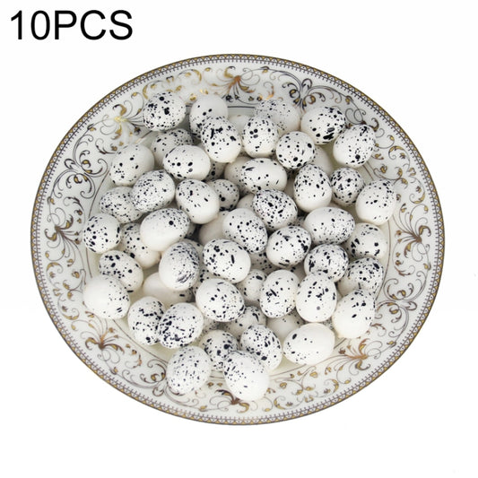 Simulated bird eggs set, white with black speckles, in decorative serving dish