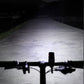 Bicycle front headlight shining a wide white beam on the road