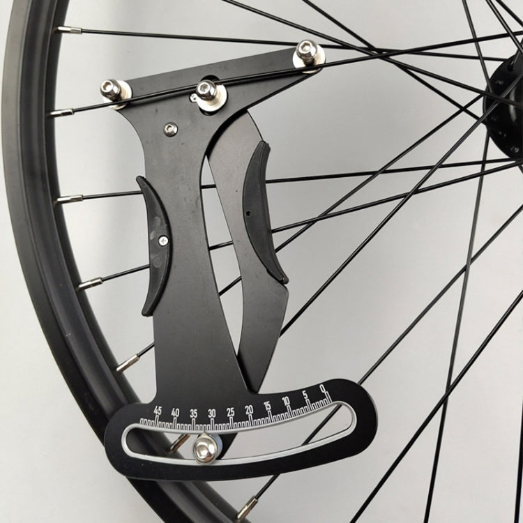 Bicycle spoke tension meter tool mounted on a wheel rim with gauge scale