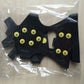 Black non-slip ice traction shoe covers with yellow studs in sealed package
