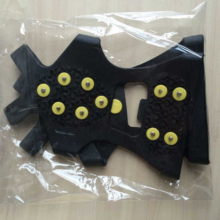 Black non-slip ice traction shoe covers with yellow studs in sealed package