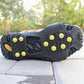 Black traction sole with yellow studs grips on concrete pavement