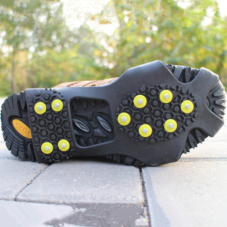 Black traction sole with yellow studs grips on concrete pavement