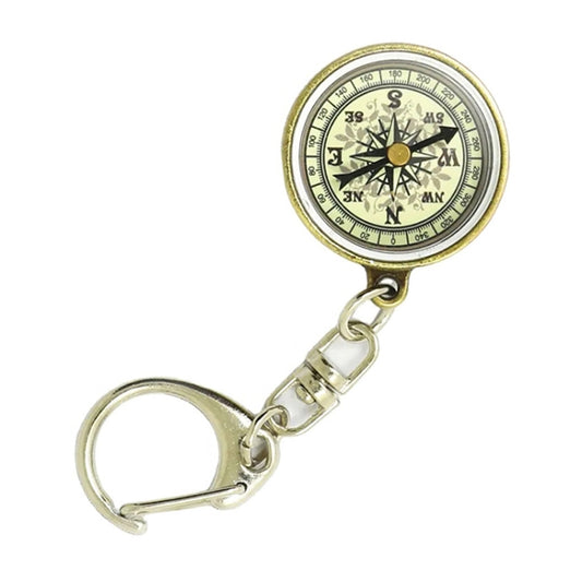 Round vintage compass keychain with black dial, gold-tone rim, and split-ring clasp.