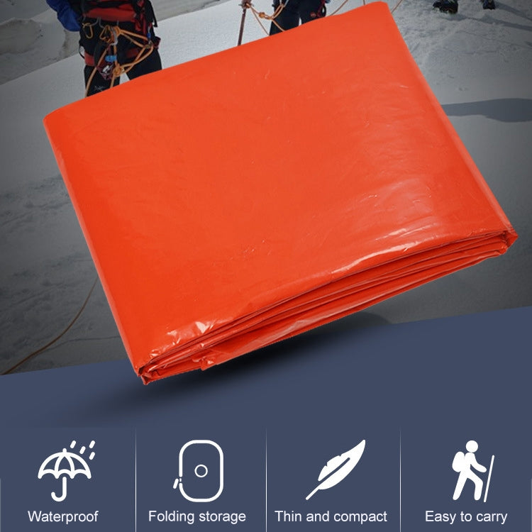 Orange long rain poncho, folded compactly in a square stack
