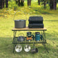 Outdoor folding bamboo desk with black mesh rack holding cookware and canisters