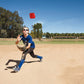 Red hexagonal reaction training ball airborne during an outdoor agility exercise