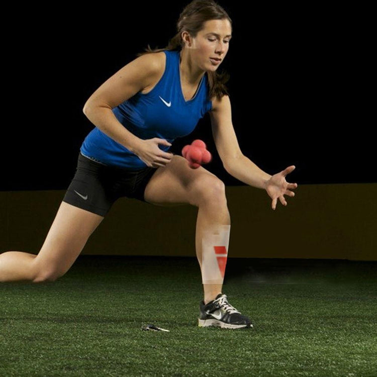 Red hexagonal reaction training ball for hand-eye coordination, gripped during a drill