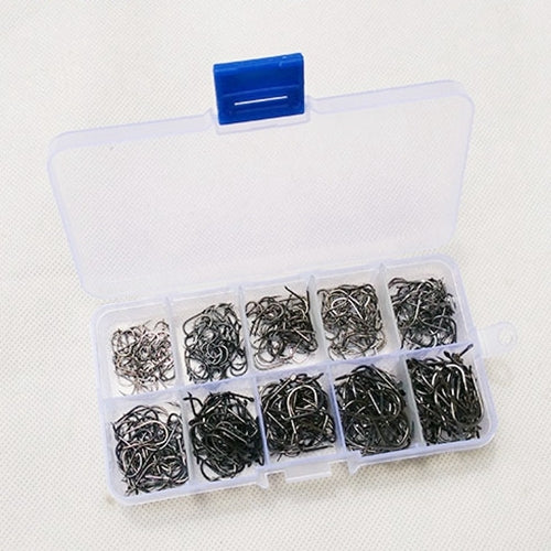 Assorted barbed fishing hooks inside clear organizer box with blue compartments