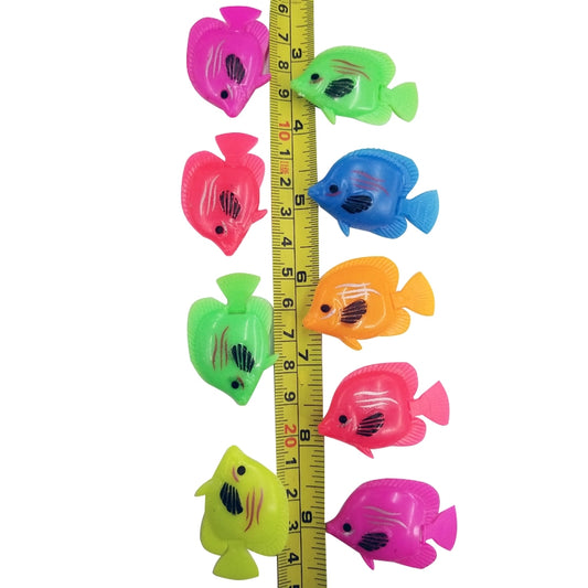 Multicolor plastic floating fish decorations shown next to a measurement ruler