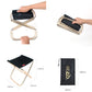 Black padded folding stool with aluminum frame, being folded by hands