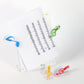 Clear music note spring page clips holding papers, with blue, green, yellow, and red notes