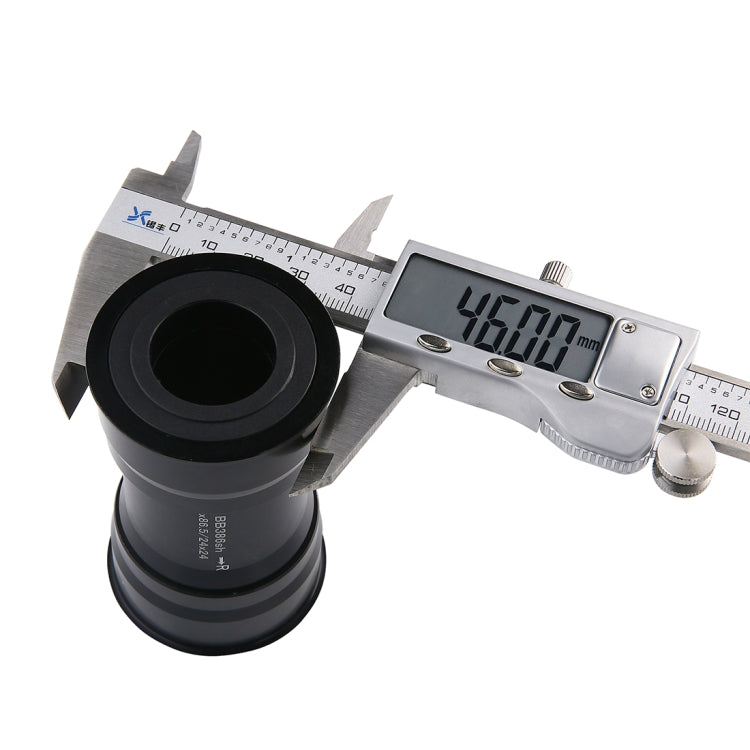 Caliper measuring a black press-fit bottom bracket cup at 46mm