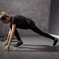 Round gliding disc under hands during plank exercise, blue edge visible