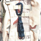 Black tri-glide buckle strap attached to a camo backpack panel