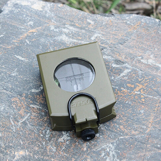 Olive green prismatic compass close-up with round sight window and focus knob