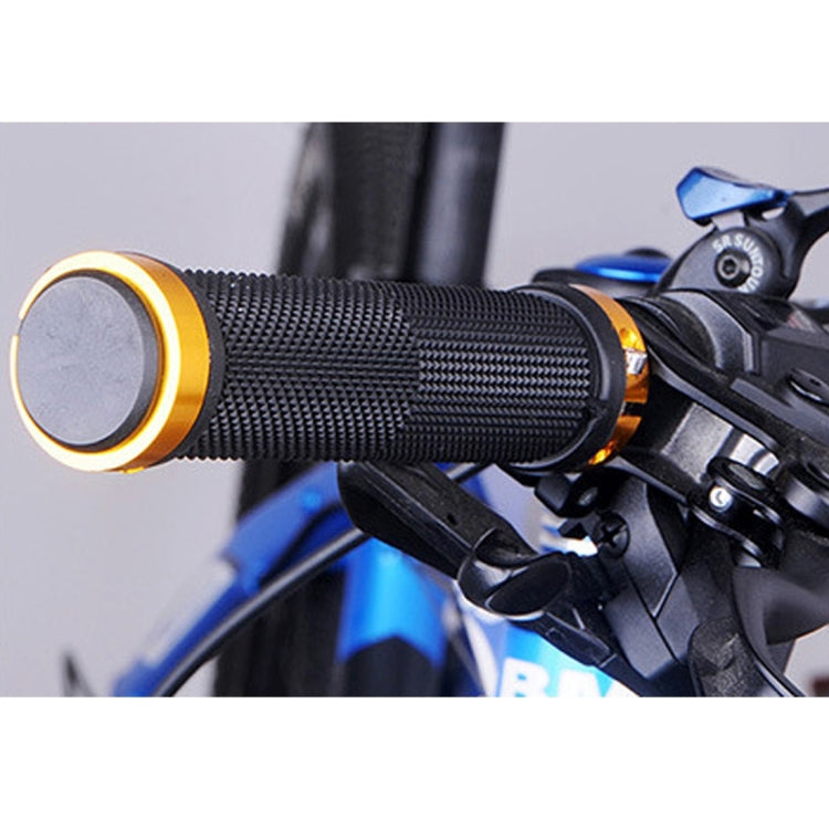 Black textured handlebar grips with gold end caps installed on bike
